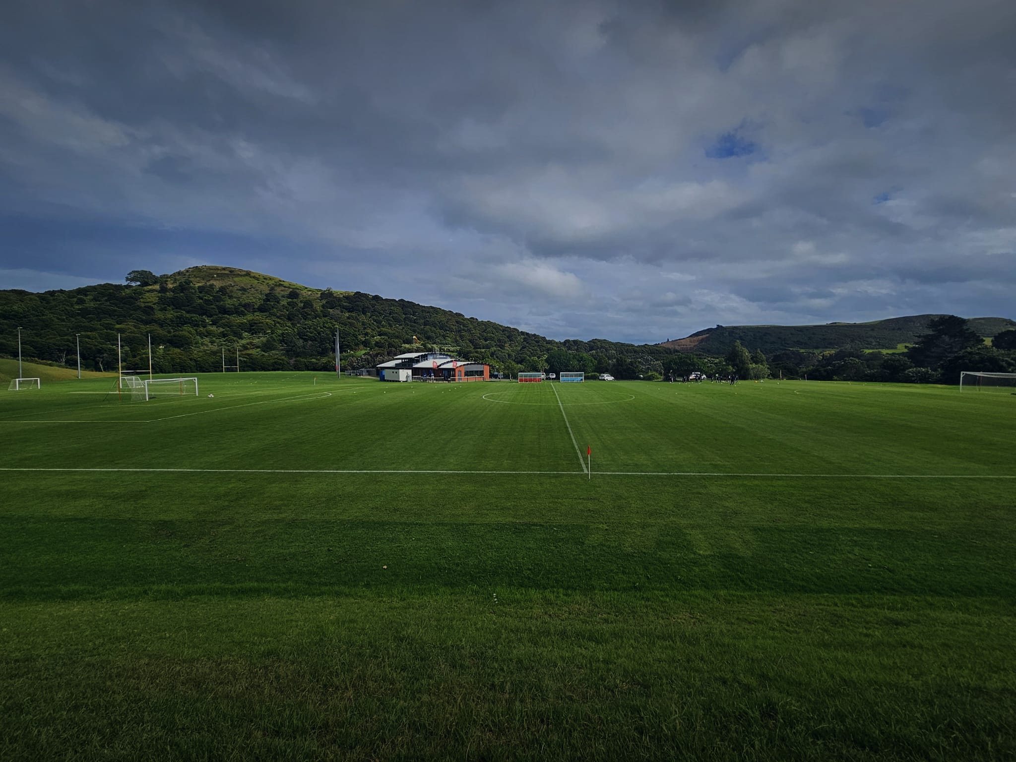 Campo de fútbol con la línea de medio campo y colinas al fondo